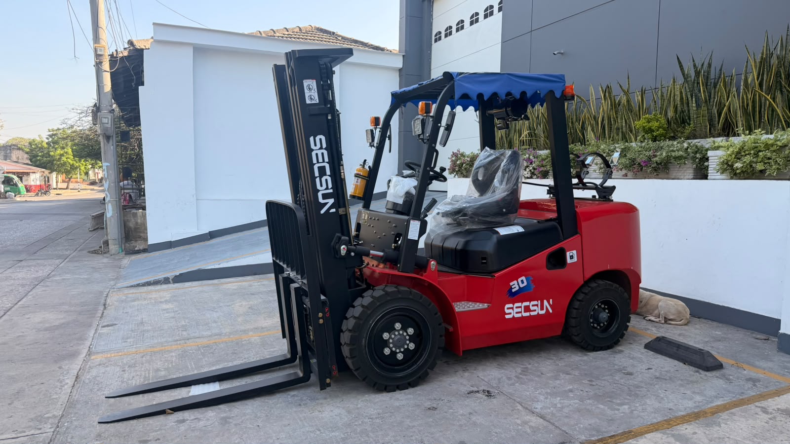 Montacargas Secsun FG30 rojo de 3 toneladas, nuevo, con mástil triple y toldo, en la sede de YOTA Montacargas en Barranquilla